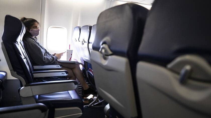 epa08578070 A passenger wearing a mask on a Southwest Airline flight waits for take off amid the coronavirus pandemic in Oakland, California, USA, 31 July 2020. EPA/ETIENNE LAURENT