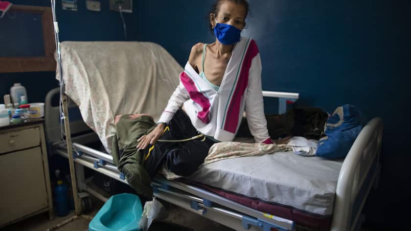 Yalitza Cadiz, who is being treated for cervical cancer, sits on her bed at the Luis Razetti hospital in Caracas, Venezuela, Tuesday, Sept 2, 2020. Consultations with new cancer patients have been suspended due to lack of water, air conditioning, supplies and doctors. (AP Photo/Ariana Cubillos)