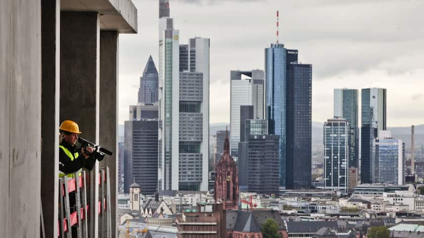 epa03196906 A camera man (L) films Frankfurt's skyline from the construction site of the new headquarters of the European Central Bank (ECB) in Frankfurt Main, Germany, 26 April 2012. Reports state that the new building next to the listed Grossmarkthalle (Wholesale Market Hall) is supposed to be finished around the end of 2013, ECB employees are expected to start working there in 2014. EPA/FRANK RUMPENHORST