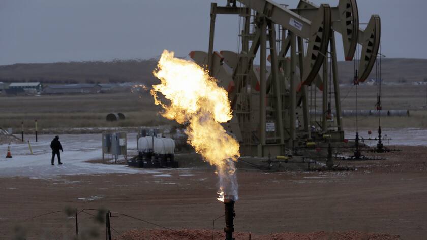FILE - In this Oct. 22, 2015, file photo, workers tend to oil pump jacks behind a natural gas flare near Watford City, N.D. Since Donald Trump took office, AmericaâÄ™s exports of liquid natural gas and crude oil have surged, rivaling the likes of Saudi Arabia and Russia. To achieve âÄœenergy dominance,âÄ the Trump administration has taken its cues from an unlikely source: the Obama administration. (AP photo/Eric Gay, File)