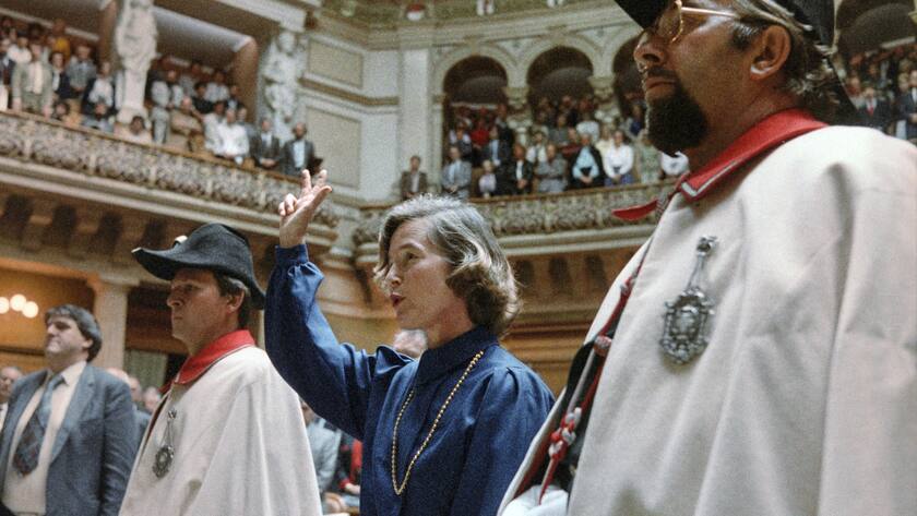 Vereidigung der ersten Frau zur Bundesraetin: In Begleitung von zwei Weibeln hebt Elisabeth Kopp am 2. Oktober 1984 in Bern bei ihrer Vereidigung im Nationalratssaal die rechte Hand zum Schwur. (KEYSTONE/Str)