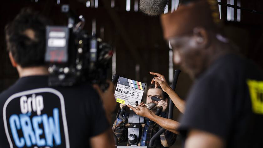 Ein Mitarbeiter der Filmcrew haelt eine Klappe bei Dreharbeiten fuer die zweite Staffel der Serie "Neumatt" produziert von Zodiac Pictures und SRF, am Dienstag, 12. April 2022 auf einem Bauernhof in Uster. (KEYSTONE/Michael Buholzer)