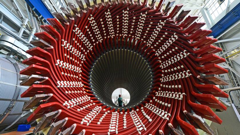 ARCHIV - 14.04.2016, Thüringen, Erfurt: Hinter einem Generatorenständer steht eine Mitarbeiterin der Factory Services im Siemens-Generatorenwerk. (zu dpa «Ostdeutscher Maschinenbau sieht Zeiten schwieriger werden») Foto: Martin Schutt/dpa-Zentralbild/dpa +++ dpa-Bildfunk +++ (KEYSTONE/DPA/Martin Schutt)