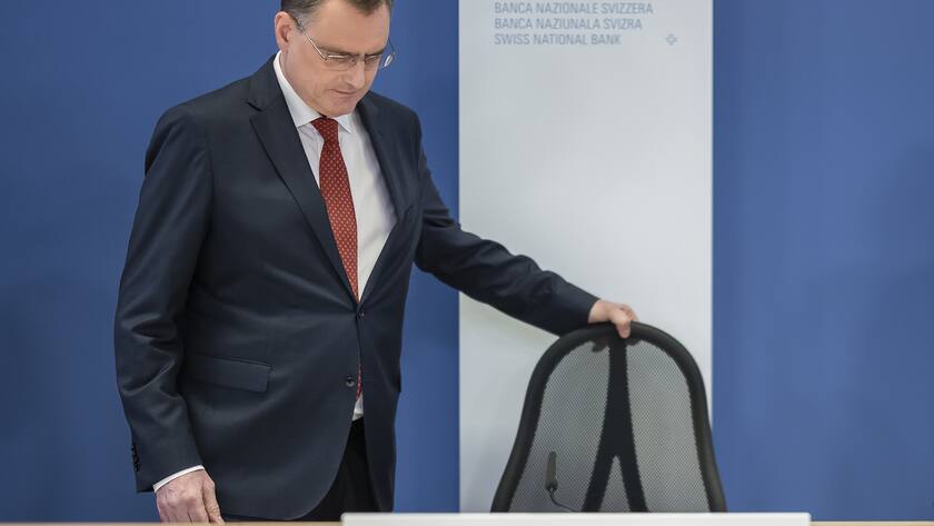 Thomas Jordan, der Präsident des Direktoriums der Schweizerischen Nationalbank hält den Stuhl mit der linken Hand an einer Pressekonferenz und blickt nach unten.