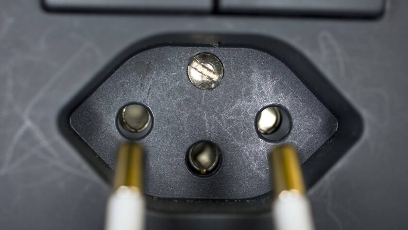 Ein zweipoliger Stecker eines Kabels wird in eine dreipolige Steckdose gesteckt, am 27. November 2006 in einer Wohnung in Zuerich. (KEYSTONE/Martin Ruetschi) === , ===