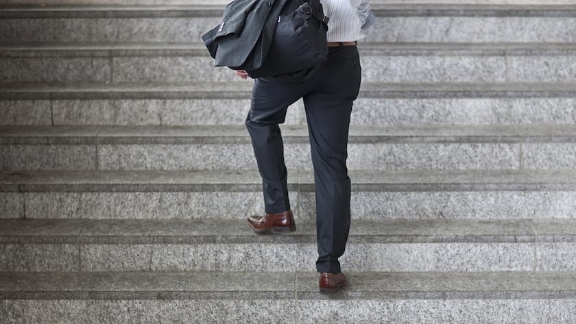 Ein Geschaeftsmann steigt eine Treppe hoch