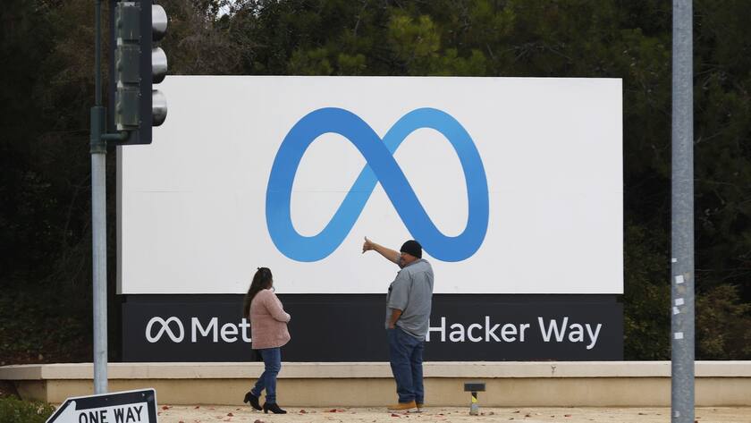epa10295086 People stand in front of a Meta sign at the headquarters of Meta Platforms Inc., formerly named Facebook, Inc., in Menlo Park, California, USA, 08 November 2022. Chief Executive Mark Zuckerberg told company executives that Meta will begin laying off employees on 09 November. EPA/JOHN G. MABANGLO