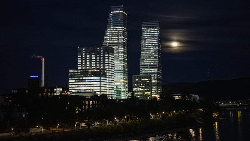 Die Lichter der Roche-Tuerme spiegeln sich im Wasser des Rheins in Basel, am Dienstag, 8. November 2022. (KEYSTONE/Georgios Kefalas)