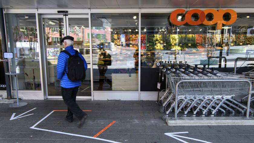 Eine Person folgt den Bodenmarkierungen vor einem Coop waehrend der Coronavirus (Covid-19) Pandemie, am Dienstag, 24. Maerz 2020 in Bern. (KEYSTONE/Anthony Anex)