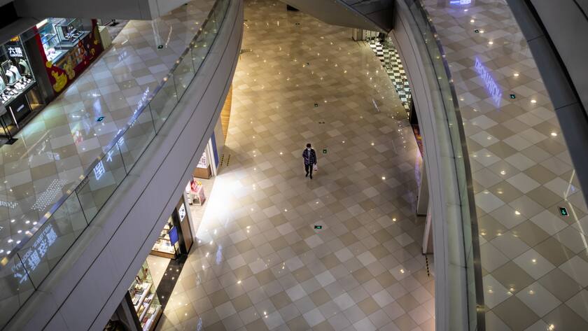 Ein Mann geht durch eine leere Shopping Mall in Guangzhou.