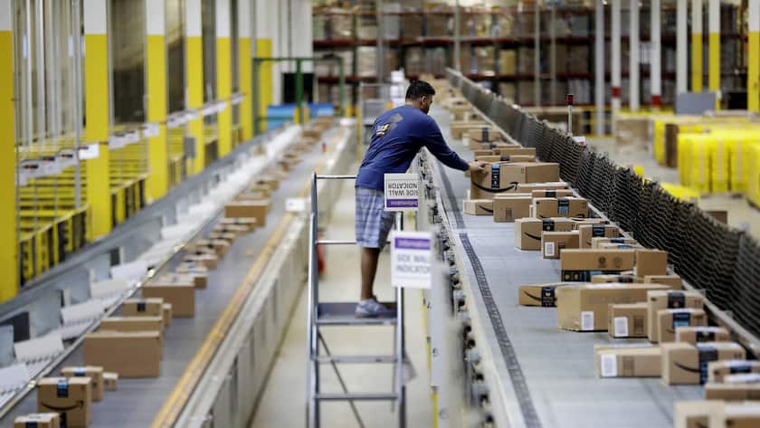 In this Tuesday, Aug. 1, 2017, photo, an Amazon employee makes sure a box riding on a belt is not sticking out at the Amazon Fulfillment center in Robbinsville Township, N.J. Amazon is holding a giant job fair Wednesday, Aug. 2, and plans to make thousands of job offers on the spot at nearly a dozen U.S. warehouses. (KEYSTONE/AP Photo/Julio Cortez)