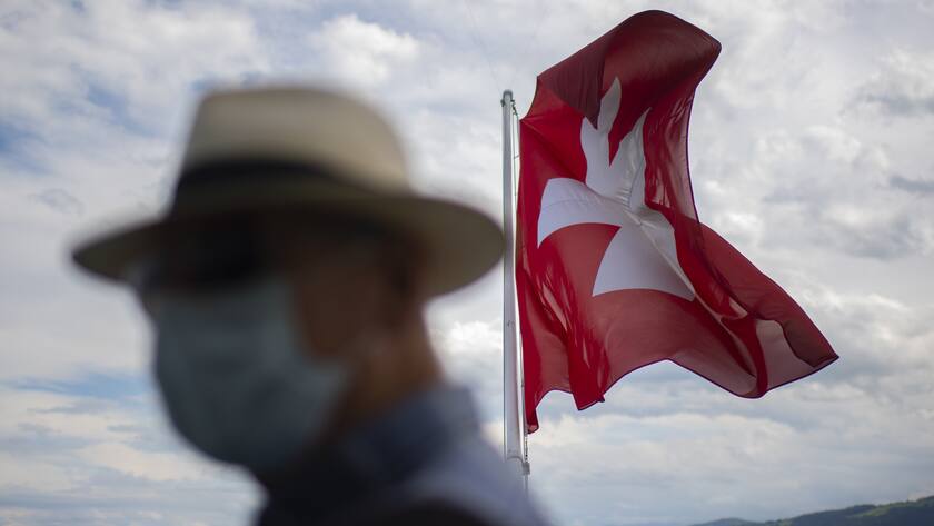 Ein Passagier mit Schutzmaske und die Schweizer Fahne auf der MS Zuerich, aufgenommen am Montag, 24. August 2020, in Romanshorn. Die Schweizerische Bodensee Schifffahrt reduziert ab heute den Fahrplan unter der Woche. Die Passagierfrequenzen seien seit dem Ausbruch von Covid-19 und der verordneten Maskenpflicht um ueber 50 Prozent eingebrochen. (KEYSTONE/Gian Ehrenzeller)