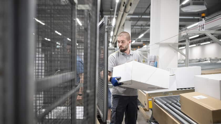 Mitarbeiter sortieren die Pakete im neuen regionalen Paketzentrum der Post im Industriegebiet Riedmatt, aufgenommen am Freitag, 20. Mai 2022 in Ruemlang Zuerich. Rund 5'000 Pakete pro Stunde werden von 60 Mitarbeiter fuer den Grossraum Zuerich-Nord verarbeitet. (KEYSTONE/Ennio Leanza)