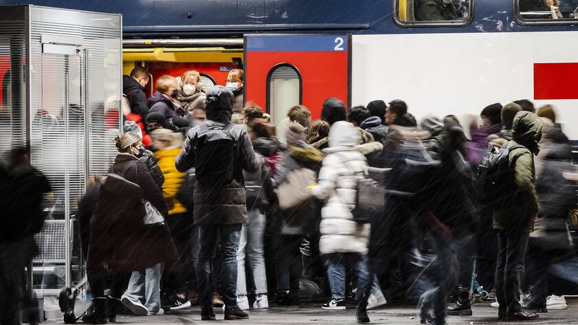 Commuters wear face masks to curb the spread of COVID-19 as they get on a public train in Zurich on Tuesday, November 30, 2021. (KEYSTONE/Michael Buholzer)