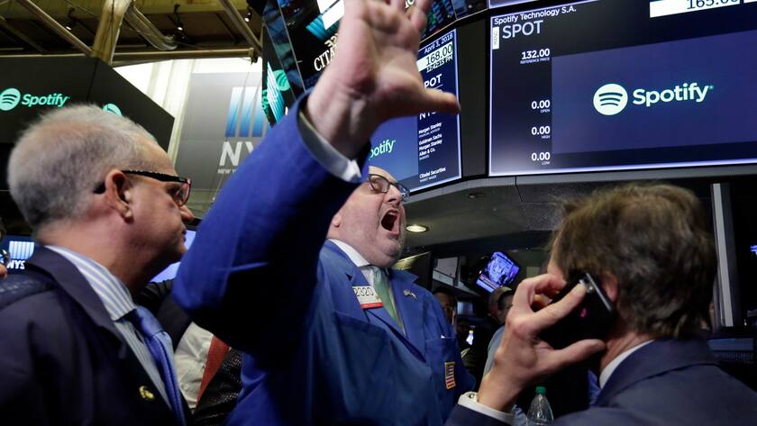 Specialist Peter Giacchi, center, declares Spotify's IPO open on the floor of the New York Stock Exchange, Tuesday, April 3, 2018. Spotify, the No. 1 music streaming service which has drawn comparisons to Netflix, is about to find out how it plays on the stock market in an unusual IPO. (AP Photo/Richard Drew)