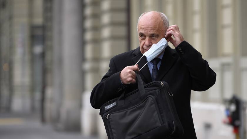 Bundesrat Ueli Maurer zieht eine Hygienemaske an, vor einer Medienkonferenz des Bundesrates zur aktuellen Lage im Zusammenhang mit dem Coronavirus, am Freitag, 11. Dezember 2020, vor dem Medienzentrum Bundeshaus in Bern. (KEYSTONE/Anthony Anex)