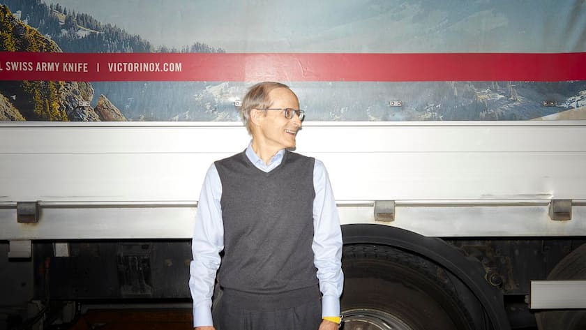 Carl Elsener vor einem Lastwagen blickt nach rechts.