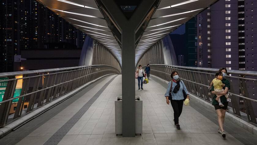 epa09559090 People cross a pedestrian bridge leading to public housing buildings in Hong Kong, China, 02 November 2021. Over 44 percent of the population in Hong Kong, about 3.3 million people, live in public housing. EPA/JEROME FAVRE
