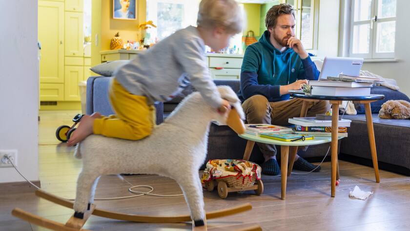 Fred, enseignant dans l'ecole vaudoise et pere de famille fait du home office depuis le salon de sa maison, en gardant son fils Oscar, suite a la fermeture des ecoles dans le canton de Vaud et dans la Suisse entiere a cause de la propagation du coronavirus (Covid-19) le lundi 16 mars 2020 a Lausanne. (KEYSTONE/Jean-Christophe Bott)