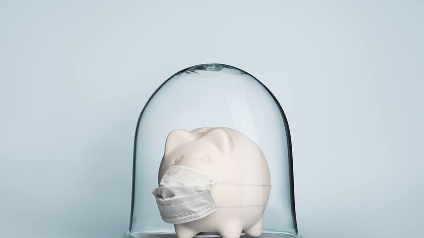 Safe economy under coronavirus concept image with piggy bank under glass jar wearing mask for protection against viruses