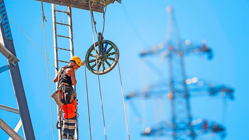 Ein Swissgrid-Arbeiter installiert ein Kabel für eine 220-Kilovolt-Freileitung.