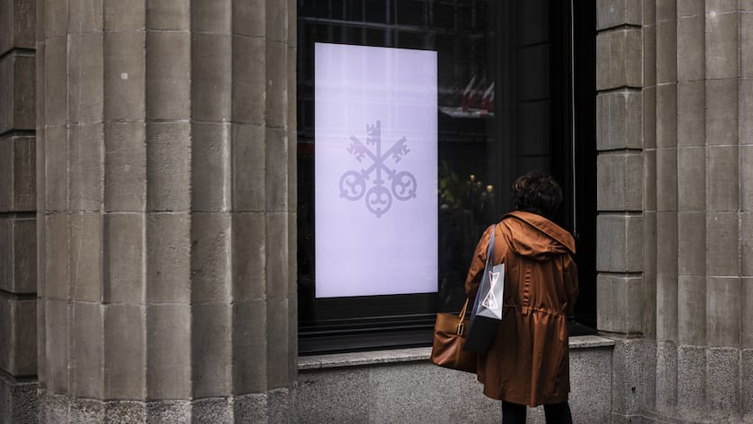 A woman looks at a screen at the entrance of the headquarters of the Swiss bank UBS in Zurich, Switzerland, on Friday, March 24, 2023. (KEYSTONE/Michael Buholzer).