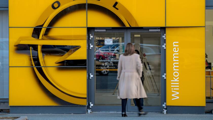 Eine Frau geht am 14.02.2017 durch Tür in einer Glasfassade mit dem Opel-Logo in Rüsselsheim (Hessen) in ein Firmengebäude des Autoherstellers. Berichten zufolge soll der französische Autokonzern PSA Peugeot Citroën Interesse an dem deutschen Automobilhersteller Opel haben. (KEYSTONE/DPA/A4658/_Andreas Arnold)