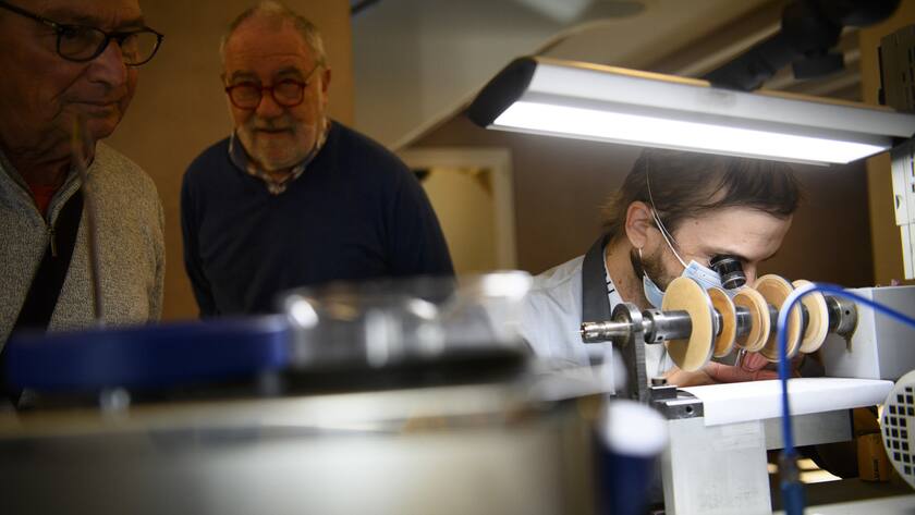 Des personnes observent le metier d'angleur en horlogerie dans l'atelier specialise dans la decoration de mouvements horlogers JBH SA lors de la 10eme Biennale du patrimoine Horloger ce samedi 6 novembre 2021 a La Chaux-de-Fonds. (KEYSTONE/Laurent Gillieron)