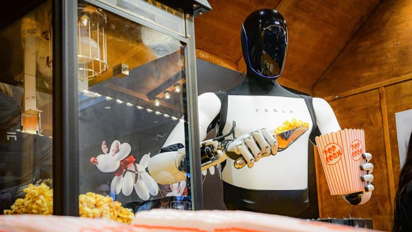 Die Giga-Wette von Tesla - und andere Gewinner der nächsten industriellen Revolution <p>Der humanoide Roboter «Optimus» von Tesla beim Abfüllen von Popcorn in eine Tüte (12.12.2025).</p>