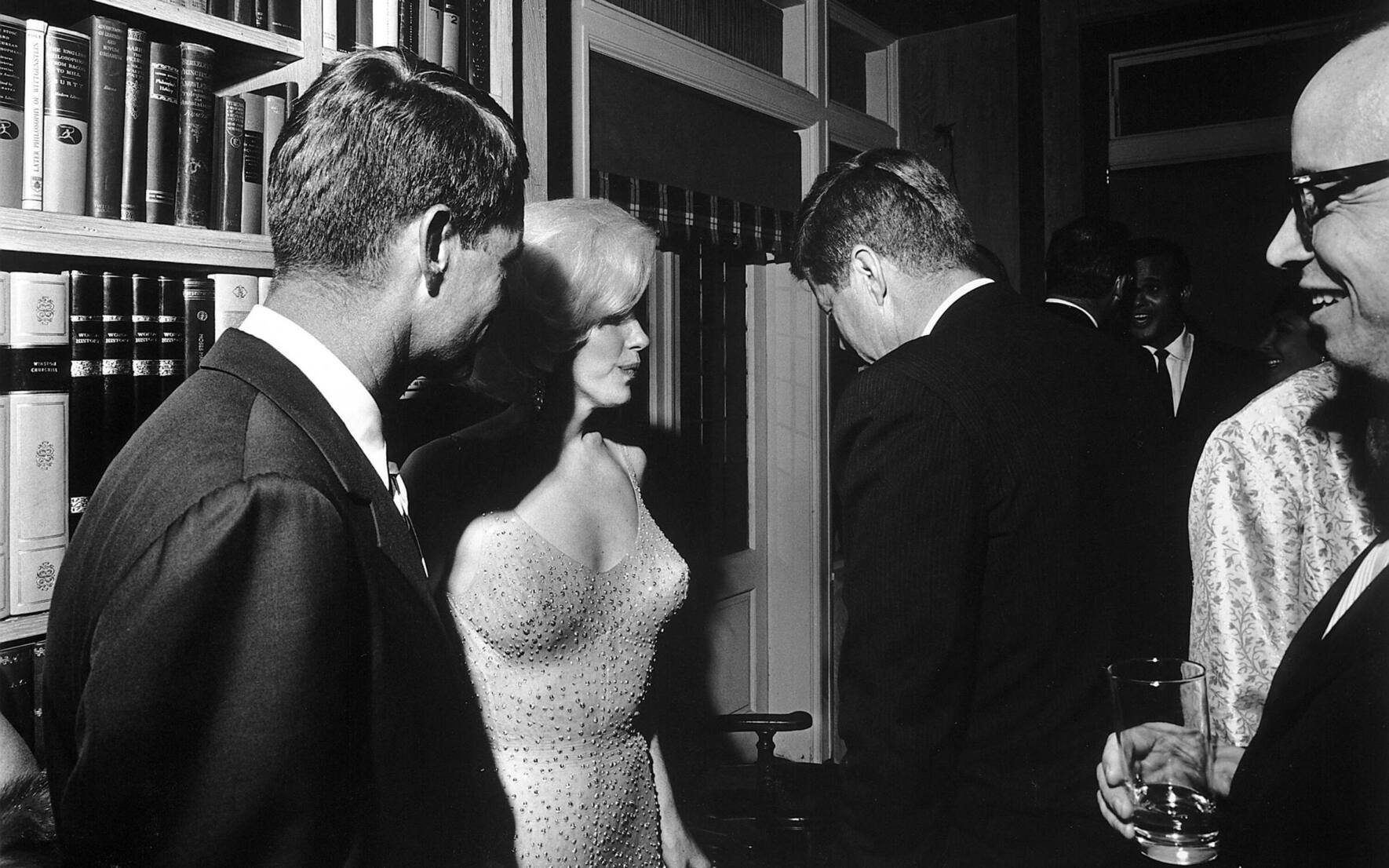 Marilyn Monroe unterhält sich nach ihrem Song mit John F. Kennedy und seinem Bruder Robert (links).