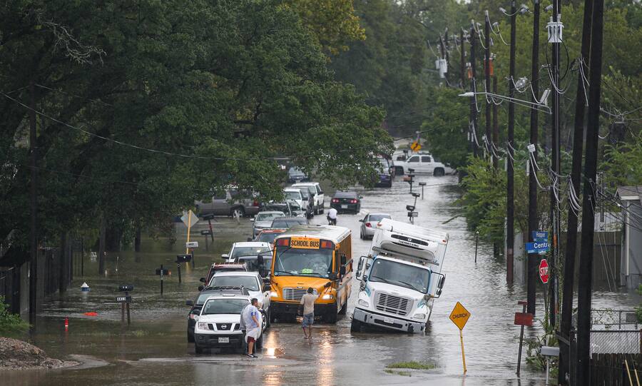 HOUSTON, TX - SEPTEMBER 19: A man tries to direct a school bus on the flooded Hopper Rd. on September 19, 2019 in Houston, Texas. Gov. Greg Abbott has declared much of Southeast Texas disaster areas after heavy rain and flooding from the remnants of Tropical Depression Imelda dumped more than two feet of water across some areas. (Photo by Thomas B. Shea/Getty Images)