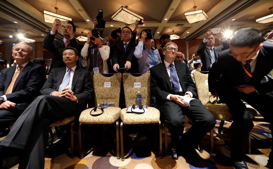 Bill Gates, seated right, co-founder of Microsoft and Chairman of TerraPower, looks on as photographers crowd behind during a signing ceremony linking China National Nuclear Corp. and TerraPower at a U.S. Trade and Investment Cooperation Conference Tuesday, Sept. 22, 2015, in Seattle. The Ministry of Commerce of China (MOFCOM), the State of Washington and partners hosted the conference to explore cooperation between Chinese provinces and U.S. businesses. (AP Photo/Elaine Thompson)