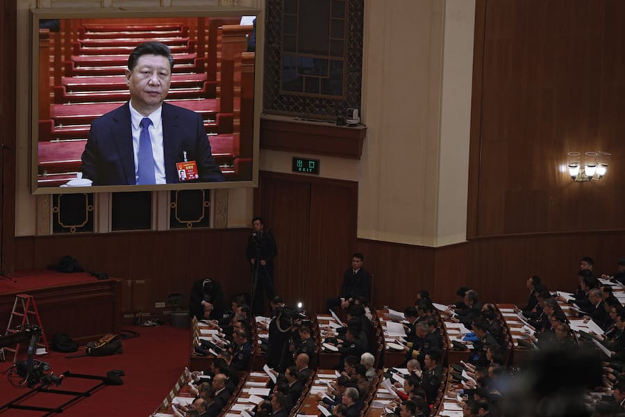Chinese President Xi Jinping is seen on a big screen as his Premier Li Keqiang delivers the work report at the opening session of the annual National People's Congress at the Great Hall of the People in Beijing, Tuesday, March 5, 2019. China's government announced a robust annual economic growth target and a 7.5 percent rise in military spending Tuesday at a legislative session overshadowed by a tariff war with Washington. (AP Photo/Andy Wong)