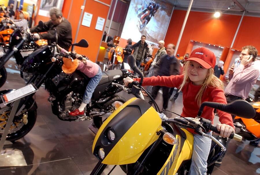 Ein Maedchen sitzt voller Stolz auf einem KTM-Motorrad, aufgenommen am Donnerstag, 19. Februar 2004, an der 1. Swiss-Moto in der Messe Zuerich. Rund 100 Aussteller zeigen auf einer Flaeche von ca. 8'900 Quadratmeter alles was das Toeff-Freak-Herz hoeher schlagen laesst. Die Ausstellung dauert bis Sonntag, 22. Februar 2004, und bietet alles fuer motorisierte Zweiraeder und sein Zubehoer. (KEYSTONE/Eddy Risch)