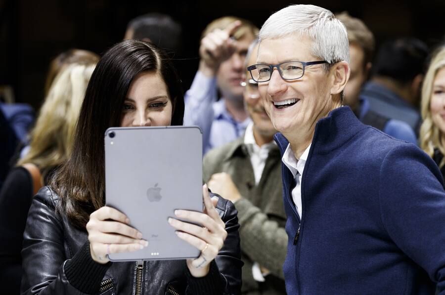 epa07131749 Apple CEO Tim Cook (R) and US singer Lana Del Rey (C) look at a new iPad Pro during an Apple hands-on event in One Hanson Place following a presentation at the Howard Gilman Opera House at the Brooklyn Academy of Music in Brooklyn, New York, USA, 30 October 2018. The event follows soon after a major Apple iPhone product launch in September 2018. EPA/JUSTIN LANE