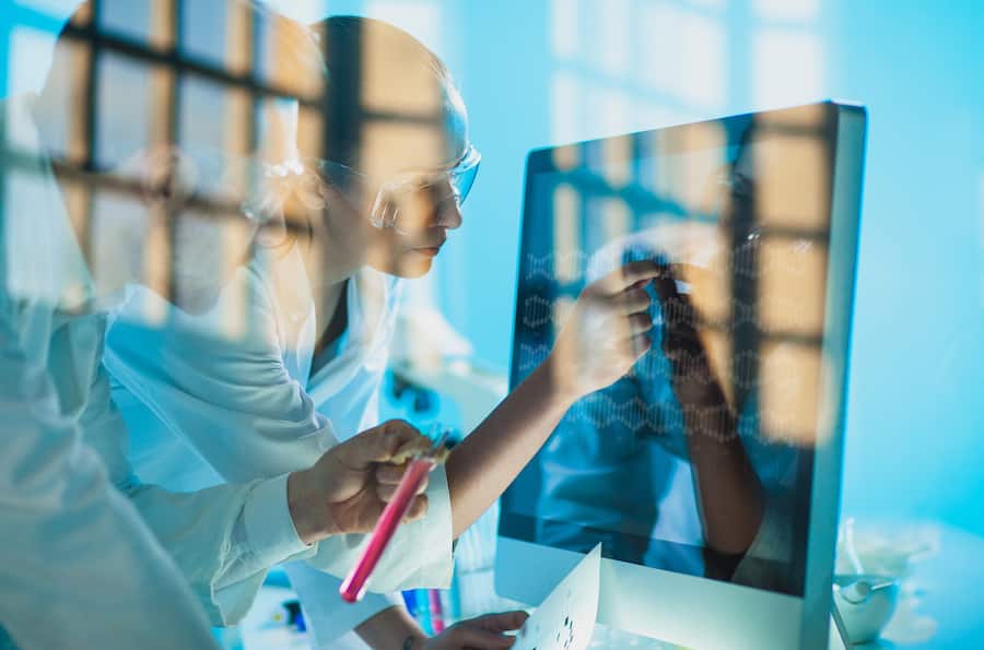scientists looking at a DNA sequence on the monitor