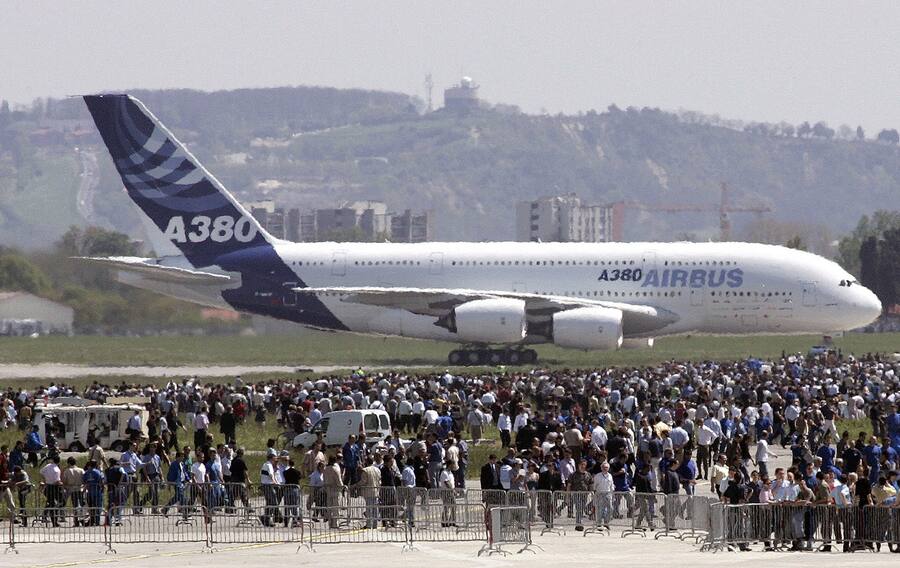 Spectators watch as the Airbus A380, the world's largest passenger plane, touches down after completing its maiden flight at Blagnac near Toulouse, southwestern France, Wednesday, April 27, 2005, in a milestone for aviation and for the European aircraft maker's battle with the American Boeing Co. The 555-seat superjumbo is expected to enter service in mid-2006. (KEYSTONE/AP Photo/Francois Mori)