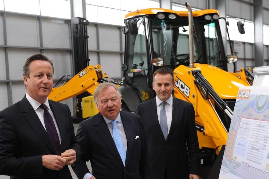 Prime Minister David Cameron is given a tour by Lord Anthony Bamford (centre) and JCB chief executive Graeme Macdonald (right) at the JCB World Logistics site in Newcastle-under-Lyme as part of the Conservative Party's European and Local Election campaign trail. (Photo by Joe Giddens/PA Images via Getty Images)