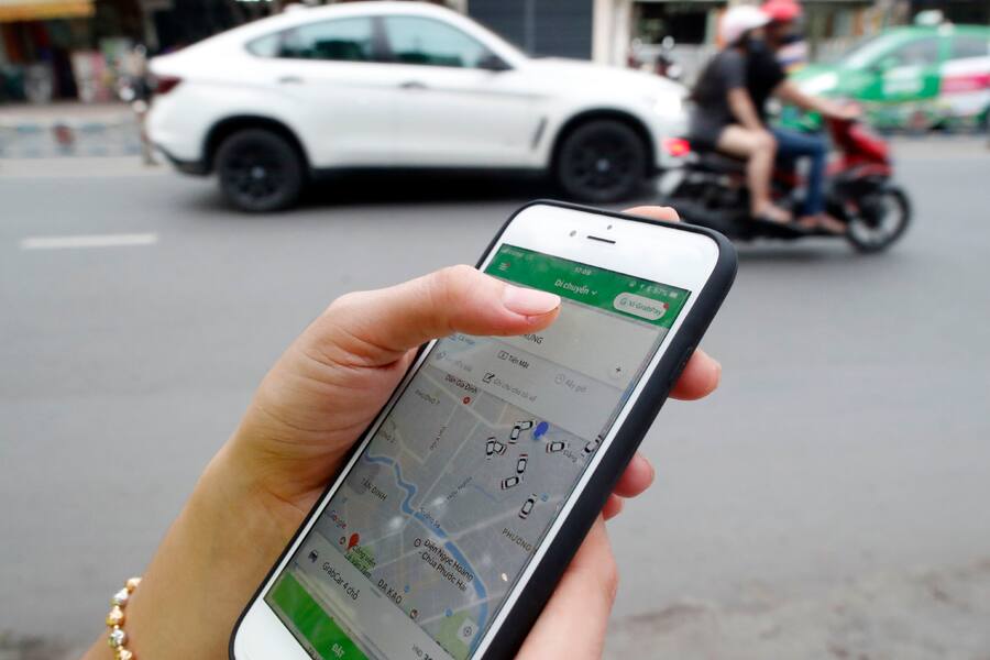 Woman using the Grab app on an Apple iPhone 6 Ho Chi Minh City Vietnam. (Photo by: BSIP/UIG via Getty Images)