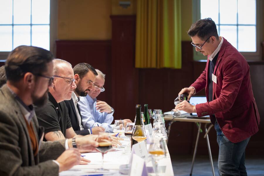 Giuliano Genoni, neuer Schweizer Meister der Bier-Sommeliers, schenkt den Jurymitgliedern Bier ein, bei der Schweizer Meisterschaft der Bier-Sommeliers, am Samstag, 20. November 2021, im Bierhuebeli in Bern. KEYSTONE/Peter Klaunzer)