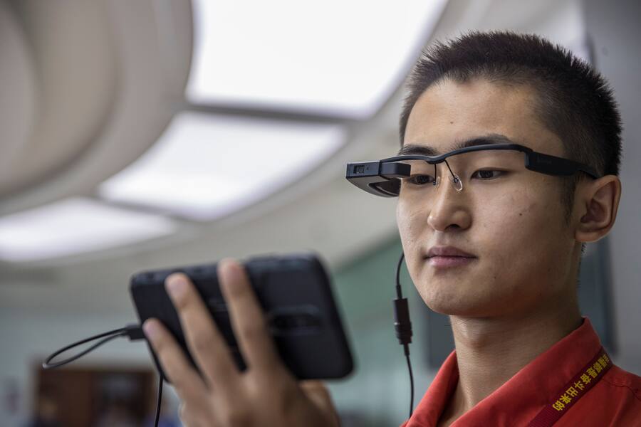 HAIKOU, CHINA - SEPTEMBER 22: A technician shows AR glasses at HNA Aviation Technic Co., Ltd. on September 22, 2020 in Haikou, Hainan Province of China. With the help of 5G network and AR glasses, maintenance technicians can receive remote technical support from engineers while repairing airplanes. (Photo by VCG/VCG via Getty Images)