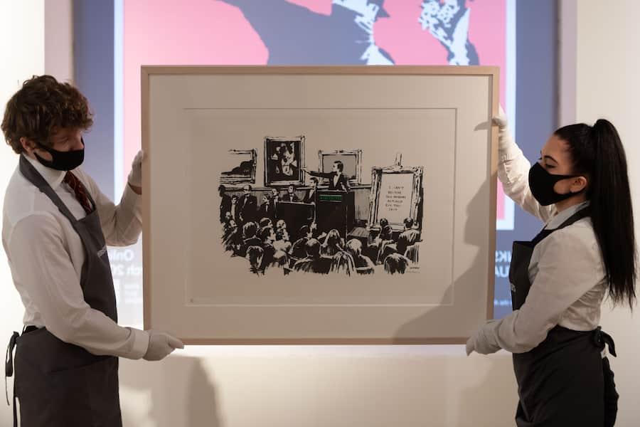 LONDON, ENGLAND - MARCH 26: Morons (White) by Banksy is displayed during preparations ahead of online sales at Christies Auction House on March 26, 2021 in London, England. The sale includes "The Prints & Multiples" and "Banksy: I Can't Believe You Morons Actually Buy This Sh*t". (Photo by Ian Gavan/Getty Images)