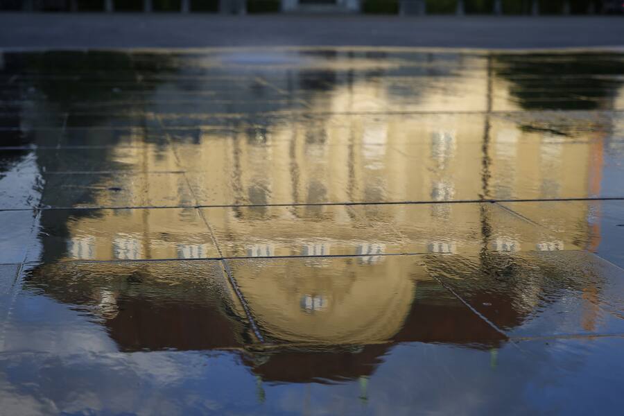 Die Nationalbank spiegelt sich im Wasser des Brunnens auf dem Bundesplatz in Bern. (KEYSTONE/Peter Klaunzer)