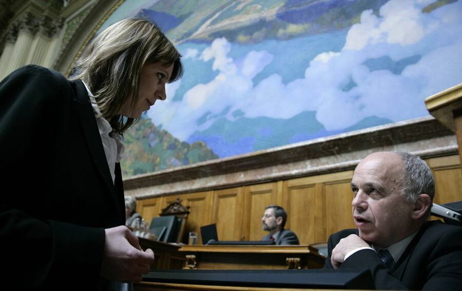Bundesrat Ueli Maurer, rechts, diskutiert mit Chantal Gallade, Nationalraetin SP-ZH, waehrend der Fruehlingssession der Eidgenoessischen Raete, am Montag, 16. Maerz 2009 im Nationalrat in Bern. (KEYSTONE/Peter Klaunzer)