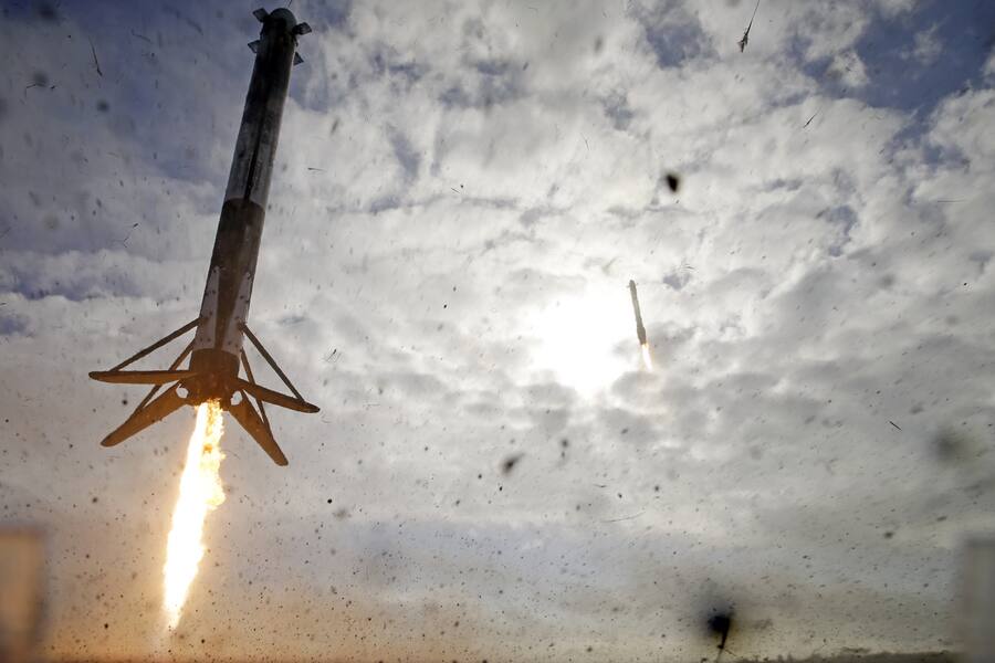 A SpaceX Falcon Heavy rocket's two side boosters, left and rear center, return to Cape Canaveral for landing about eight minutes after liftoff in Cape Canaveral, Fla., Tuesday, Nov. 1, 2022. SpaceX launched its mega Falcon Heavy rocket for the first time in more than three years Tuesday, hoisting satellites for the military and then nailing side-by-side booster landings back near the pad. (AP Photo/John Raoux)