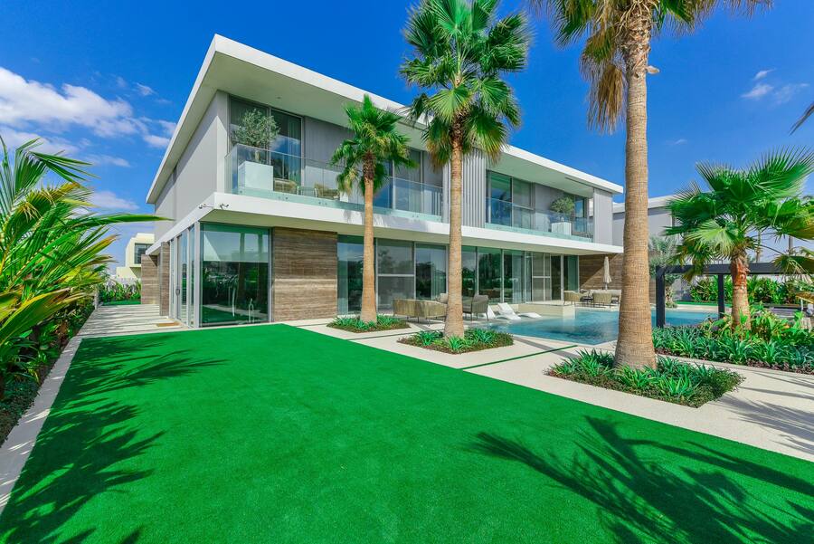 Aussenaufnahme einer Villa mit Rasen und Palmen