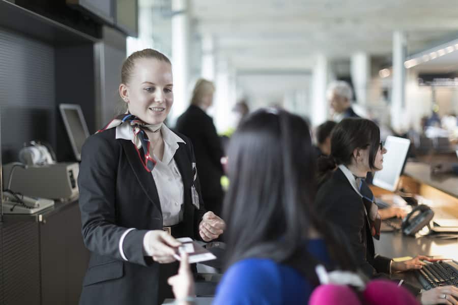 A Swissport employee checks the passports and boarding passes of the passangers