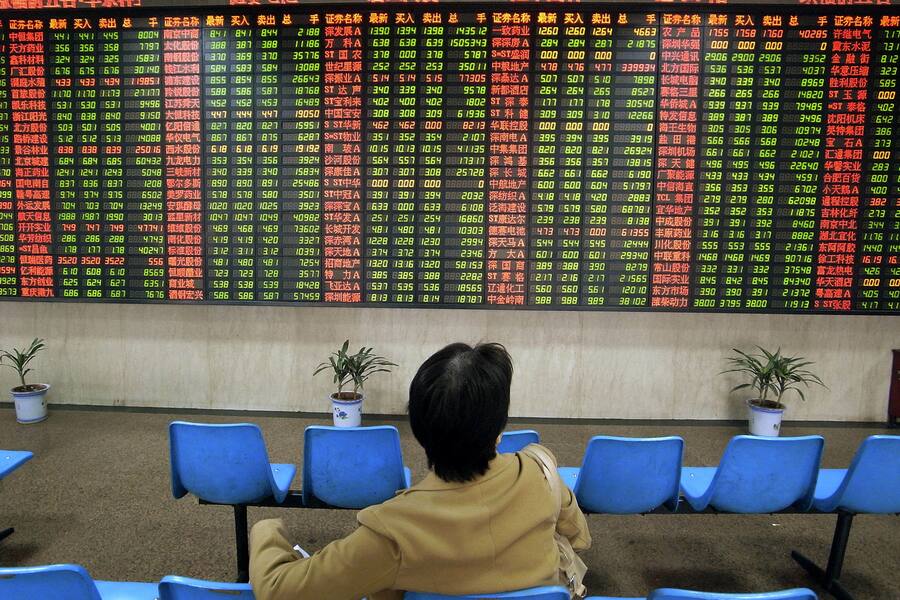 An investor looks at the stock price monitor at a private security company.