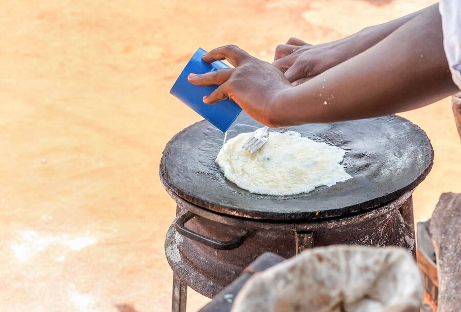 Preparation of traditional Ugandan breakfast Rolex made with chapati and eggs