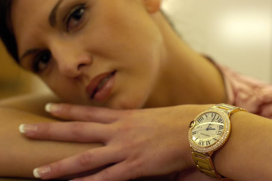 Eine Hostess posiert mit einer Ballon-Bleu-Uhr von Cartier.